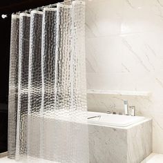 a bathroom with marble walls and flooring, shower curtain in the shape of bubbles