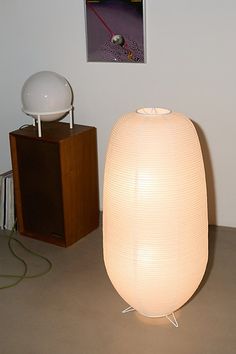 a large white lamp sitting on top of a table next to a wooden box and record player