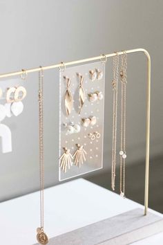 a jewelry display with earrings, necklaces and rings hanging from it's sides