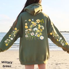 Elevate your wardrobe with this captivating and vibrantly colored hoodie, embellished with a stunning wildflower design across the back and sleeves. This hoodie is thoughtfully designed to bring a touch of nature's splendor into your daily wear. Adorned with bright and cheerful wildflowers, it exudes a sense of warmth and joy. Combining stylish flair with ultimate comfort, this hoodie is a must-have for anyone's collection. Whether you're enjoying a leisurely walk, spending a cozy evening indoor Graphic Print Hoodie Sweatshirt For Spring, Green Hooded Hoodie For Spring, Green Hoodie Tops For Spring, Green Hoodie Sweatshirt For Spring, Green Hoodie With Drawstring For Spring, Green Hooded Top For Spring, Trendy Green Hoodie For Spring, Spring Green Hoodie Top, Yellow Hooded Sweatshirt For Spring