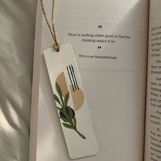 a bookmark with an image of forks and spoons on it hanging from a string