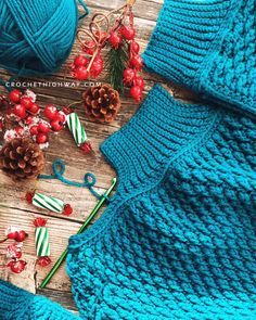 a blue knitted sweater with pine cones and candy canes on the table next to it