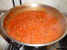 a pot filled with red sauce on top of a stove