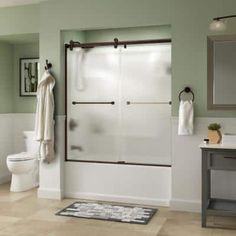 a bath room with a toilet a sink and a shower stall in the middle of it