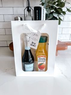 two bottles of alcohol in a white gift bag