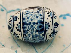 a blue and white vase sitting on top of a piece of paper with designs on it