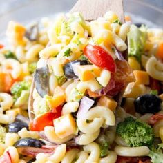 a pasta salad with broccoli, tomatoes, black olives and other vegetables