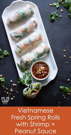 vietnamese spring rolls with shrimp and peanut sauce on a white platter next to a bowl of dipping sauce