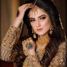 a beautiful woman with long hair and jewelry on her head, posing for the camera