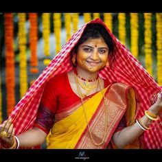 a woman dressed in yellow and red holding something