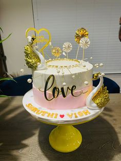 a cake that is sitting on top of a table with gold decorations and confetti