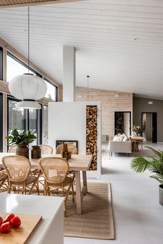 a dining room and living room with large windows in the back ground, wood accents on the walls