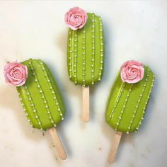 three green and pink popsicles with flowers on them