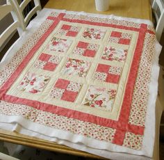 a quilted table runner on a dining room table