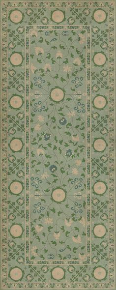 a green rug with flowers and leaves on the bottom, in an ornate border pattern