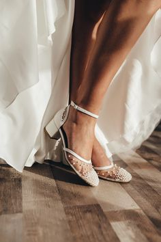 a bride's shoes and dress are shown on the floor in front of her