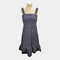 Awesome vintage denim jumper dress by Betsey Johnson! Adjustable straps, back zip, empire waist, two front patch pockets and a ruffled hem. Size 4. Cotton with 2% lycra for a little stretch. Great condition!  Measurements taken laid flat -  Bust: 17" Waist: 14" Hips: 19"  Length: 36" Fitted Denim Dress With Ruffle Hem, Sleeveless Denim Blue Ruffled Denim Dress, Casual Sleeveless Denim Dress With Ruffles, Fitted Medium Wash Denim Dress With Ruffles, Sleeveless Cotton Denim Dress With Ruffles, Summer Denim Jumpsuit With Ruffles, Medium Wash Denim Dress With Ruffle Hem, Fitted Blue Denim Dress With Ruffle Hem, Casual Medium Wash Denim Dress With Ruffle Hem