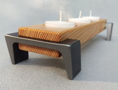 two candles sit on top of a wooden bench that is made out of plywood