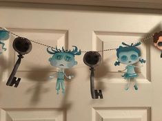 some paper dolls are hanging on a line by the door with clothes pins attached to them