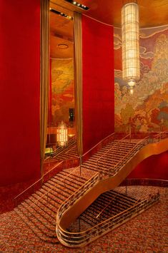 a staircase in a room with red walls and chandelier