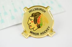 a gold pin with the words, millisburg minor hockey written in black on it