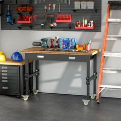 a workbench with tools on it in front of a wall mounted tool rack