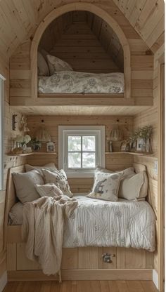 a bed sitting under a window in a bedroom next to a wooden wall and floor