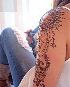 a woman's arm with henna tattoos on it