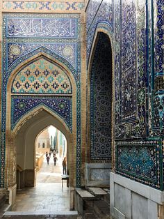 an archway in the middle of a building with blue and white tiles on it's walls