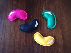 three different colored eye masks sitting on top of a wooden table