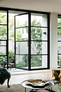 a living room filled with furniture and lots of glass doors that open up to the outside