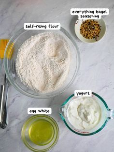 ingredients to make an egg white cake laid out on a marble counter top, including eggs, flour, butter, and sugar