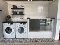 a washer and dryer in a room with white tiles on the floor,