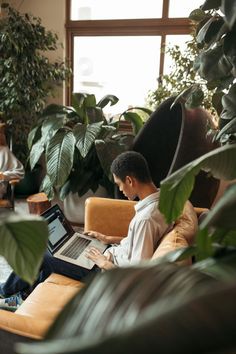 a man sitting on a couch using a laptop computer