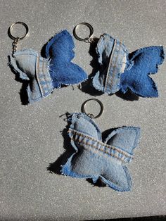 three pieces of blue jean fabric that have been pinned to each other with metal rings