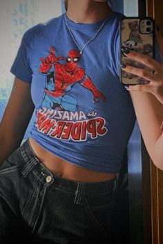 a woman taking a selfie in front of a mirror wearing a spiderman t - shirt