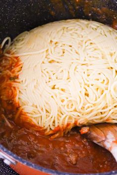 a pot filled with pasta and sauce on top of a stove