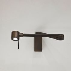 a wall mounted light on the side of a white wall