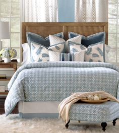 a bed with blue and white comforters in a bedroom