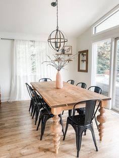 a dining room table with chairs and a chandelier hanging from it's ceiling