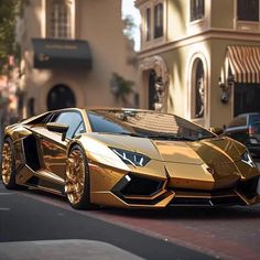 a gold colored sports car parked in front of a building on the side of a street