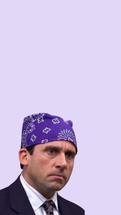 a man in a suit and tie with a purple bandanna on his head is staring at the camera