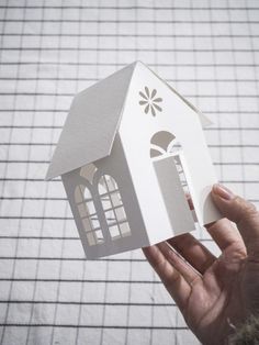 someone is holding up a paper house that looks like it has been cut out to look like a house