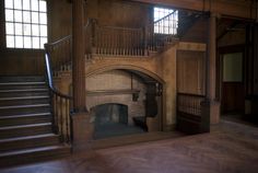 an empty room with stairs and a fire place