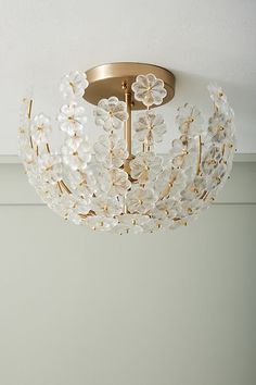 a chandelier hanging from the ceiling in a room with white walls and flooring