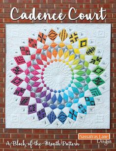 a colorful quilt hanging on a brick wall with the words,'cachent court'in