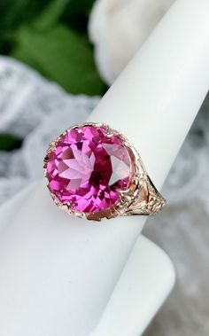 Natural Pink Topaz Ring Princess Design#29 Custom Made Inspired by Georgian and Victorian era filigree designs, I now offer this stunning reproduction in sterling silver with rose gold overlay. This fabulous ring is set with a 7.48ct VVS natural genuine pink topaz gemstone. The round full cut high quality gemstone is 13mm (1/2th of an inch) in diameter. The gemstone has excellent color and clarity. The inside of the band is marked 925 for sterling. Notice the beautiful intricate leaf prongs and Elegant Rose Gold Topaz Birthstone Ring, Heirloom Rose Gold Topaz Gemstone Ring, Rose Gold Topaz Gemstone Ring, Rose Gold Topaz Ring With Gemstone, Victorian Princess, Topas Ring, Pink Topaz Ring, Princess Design, Mystic Fire Topaz