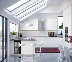 a modern kitchen with white cabinets and black counter tops is seen from the dining room