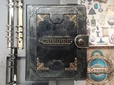 a black book with the word grimoire written on it next to other books and papers