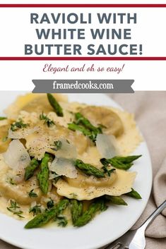 a white plate topped with ravioli and asparagus next to a silver fork